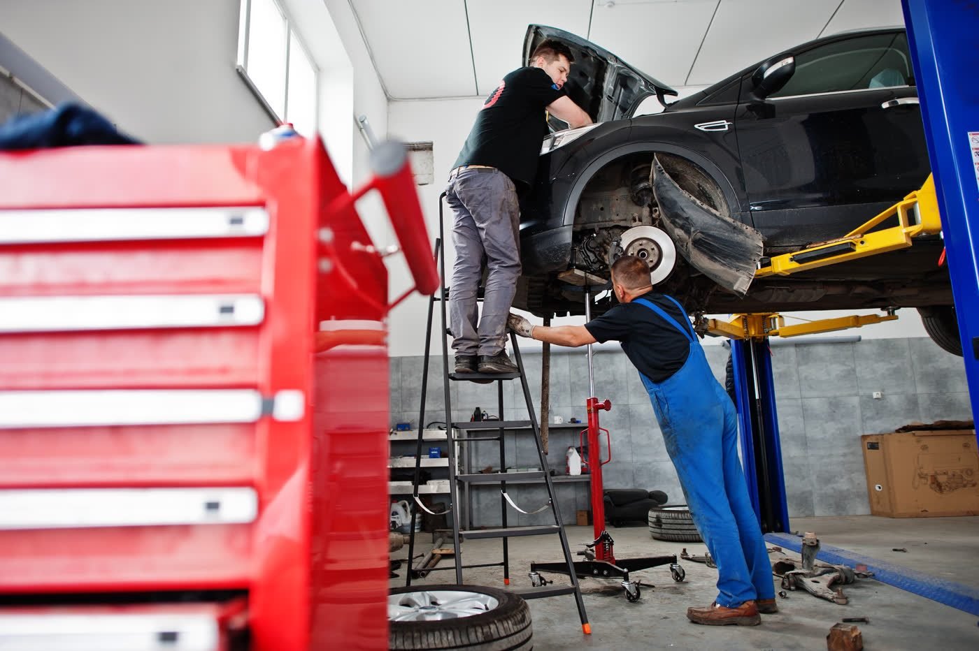 Hobbywerkstatt von TRUXTEC mit Hebebühnen zum Selberschrauben – Mechaniker an einem Fahrzeug auf der Hebebühne